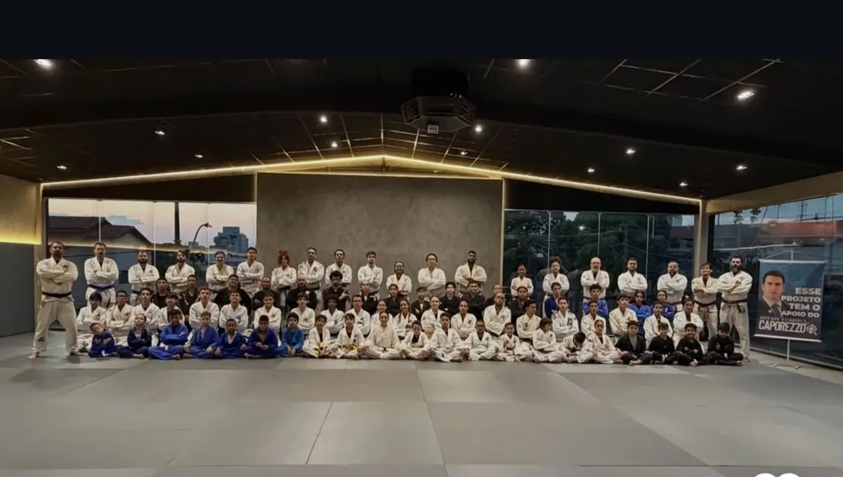 Turma grande de alunos de kimono sentados no tatame