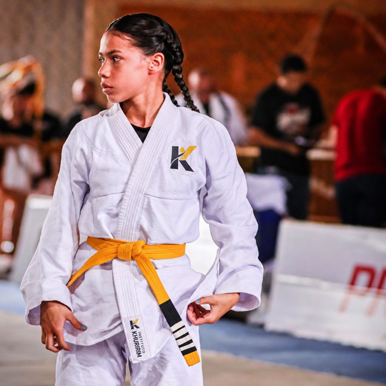 Aluna de kimono branco com faixa amarela de jiu-jítsu